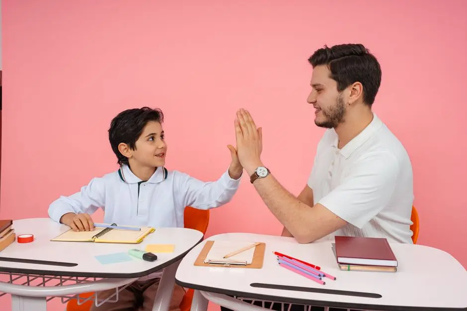 Seorang siswa dan tutor sedang belajar di meja dengan buku dan laptop